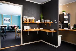 a room with black walls and tables and a kitchen at Hotell Veckefjärden in Örnsköldsvik