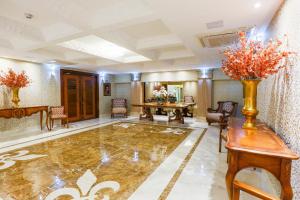 a hotel lobby with a table and chairs and a vase of flowers at Golden Lis Hotel Boutique in Goiânia