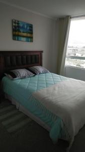 Una cama grande en un dormitorio con ventana. en La Serena hermosa, en La Serena 25 fotos más