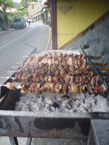 a bunch of chickens are cooking on a grill at Mountain Rose Hotel & Restaurant in Pedoulas