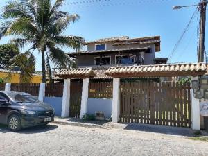 a car parked in front of a fence in front of a house at Ilha do Village in Cabo Frio