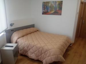 - une chambre avec un lit, une table et une photo dans l'établissement Hostal Outarelo, à Ourense