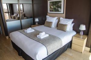 - une chambre avec un grand lit blanc et des serviettes dans l'établissement Haut Lofts - Toulouse Centre Ramblas, à Toulouse