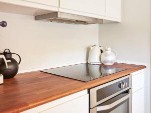 cocina con armarios blancos y encimera en 8 person holiday home in Gudhjem, en Gudhjem