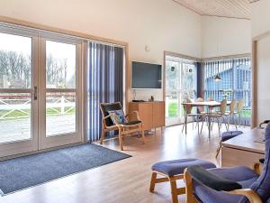 グドイェムにある8 person holiday home in Gudhjemのリビングルーム(テレビ、テーブル、椅子付)