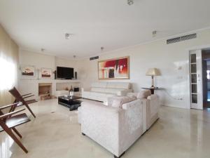 a white living room with a couch and a tv at Entire floor parque nacoes prime apartments expo30 in Lisbon