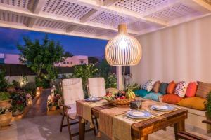 Yiasemi Luxury Suite في ماليا: غرفة معيشة مع طاولة وأريكة