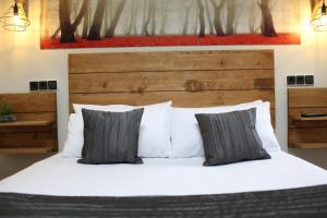1 dormitorio con 1 cama con sábanas y almohadas blancas en Priorat Boutique, en Banyeres del Penedés