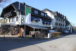 a building with a flag on the side of a street at Hotel Victoria in Hövelhof