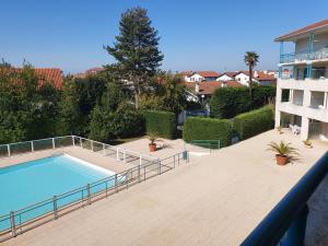 a large swimming pool on a patio next to a building at Appartement Golf et Nivelle avec piscine et parking in Ciboure