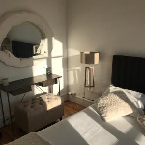 a bedroom with a bed and a mirror and a chair at Paris My 16ème in Boulogne-Billancourt