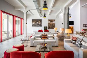 uma sala de estar com mobiliário branco e cadeiras vermelhas em Hotel da Barrosinha em Alcácer do Sal