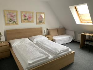 a bedroom with a large bed and a couch at Penzion Holiday in Trnava