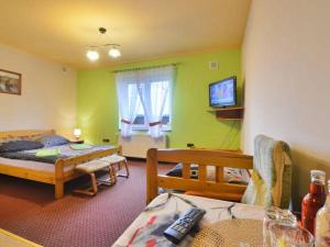 a room with two beds and a tv in it at Zajazd Mistral in Nowa Wieś