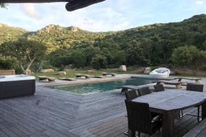 d'une terrasse avec une table et des chaises à côté de la piscine. dans l'établissement Villa piscine chauffée 5mn de la plage, à Figari