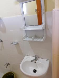 a bathroom with a white sink and a mirror at ISLET VIEW Pension House ( Formerly Island View Pension House ) in Oslob