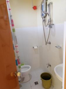 a bathroom with a shower and a toilet and a bucket at ISLET VIEW Pension House ( Formerly Island View Pension House ) in Oslob