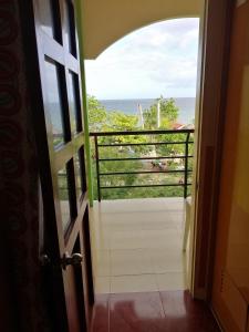 a door to a balcony with a view of the ocean at ISLET VIEW Pension House ( Formerly Island View Pension House ) in Oslob