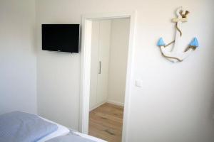 ein Schlafzimmer mit einer Wand, einem TV und einem Anker in der Unterkunft Große Ferienwohnung 3 mit Meerblick und Strandkorb im Haus Seeluft Duhnen in Cuxhaven
