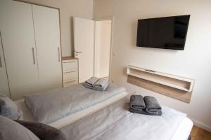 uma sala de estar com duas camas com chinelos em Ferienwohnung-2-Strandnah-und-mit-Strandkorb-im-Haus-Seeluft-in-Duhnen em Cuxhaven
