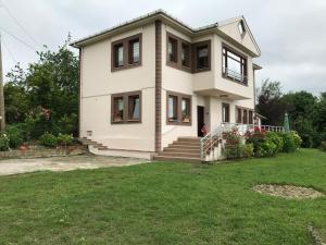 een groot wit huis met een groene tuin bij Sea & Nature Villa Hisar in Trabzon