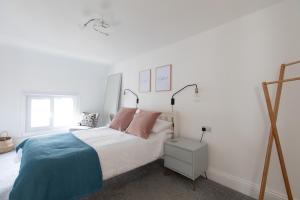 um quarto com uma cama com almofadas cor-de-rosa e azuis em Sea Front Apartment em Saltburn-by-the-Sea