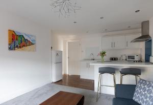 a kitchen and living room with white cabinets and a table at Sea Front Apartment in Saltburn-by-the-Sea