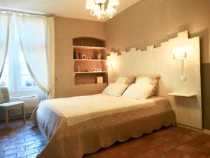 a bedroom with a bed and a chandelier at Un Patio en Luberon in Ansouis