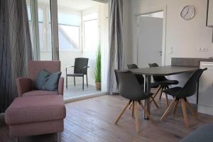 ein Wohnzimmer mit einem Esstisch und Stühlen in der Unterkunft Große Ferienwohnung 3 mit Meerblick und Strandkorb im Haus Seeluft Duhnen in Cuxhaven