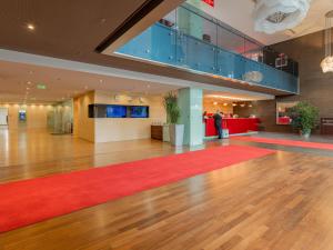 an empty lobby with a red carpet and a staircase at Ramada Sibiu Hotel in Sibiu