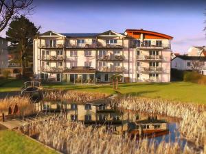 ein großes Apartmenthaus neben einem Wasserkörper in der Unterkunft Villa Nause - Meerblick & Spa in Sassnitz