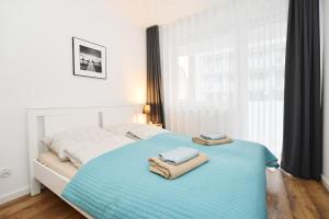 sypialnia z łóżkiem i ręcznikami w obiekcie Apartament "Bliżej Morza 30" w Kołobrzegu