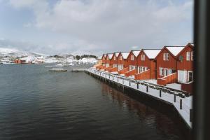 a row of houses next to a body of water at Fab scenery in Ballstad