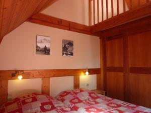 a bedroom with a bed with a red and white comforter at Hotel Auberge Edelweiss in La Grave