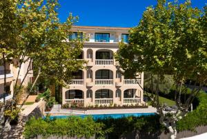 una vista aérea de un gran edificio blanco con piscina en Apartamentos S'Olivera en Canyamel