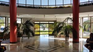 a lobby with two palm trees in a building at Санаторий Самшитовая роща in Pizunda