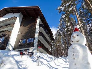 a snowman in the snow in front of a building at RESIDENCE ALICE NEL PAESE DELL' ARMENTAROLA in San Cassiano