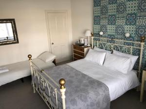 a bedroom with two beds and a mirror at Hotel 50 in Bournemouth