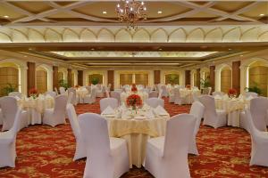 a banquet hall with white tables and chairs and a chandelier at Best Western Plus Jalandhar in Jalandhar