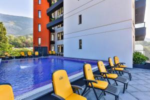 una piscina con sedie gialle e un edificio di Hotel Del Medio a Sutomore