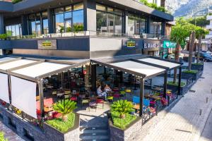 un restaurante con mesas y sillas frente a un edificio en Art-Hotel Del Medio en Sutomore