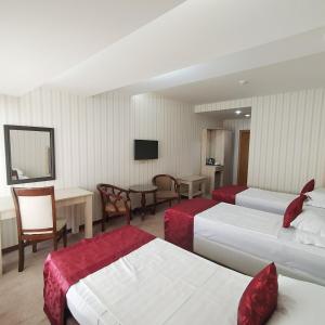 a hotel room with two beds and a television at Royal Hotel in Baku