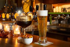 a glass of beer and a bowl of fruit on a bar at Herberg Oud Holset in Lemiers