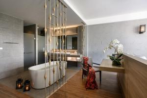 a bathroom with a tub and a sink and a desk at iSanook Resort & Suites Hua Hin in Hua Hin