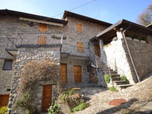 a large stone house with a staircase in front of it at Rustico Lago di Como b&b in Barna