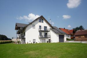 a large white house with a green lawn at Ute's Pension in Georgenberg