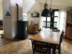 a dining room with a wooden table and a refrigerator at Forest Guesthouse in Bergentheim