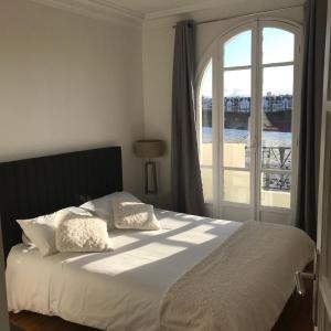 a bedroom with a bed with a large window at Paris My 16ème in Boulogne-Billancourt