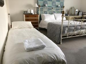 a bedroom with two beds with towels on them at Hotel 50 in Bournemouth