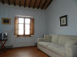 uma sala de estar com um sofá e uma janela em Angolo Alla Fortezza - Gigliola Contucci em Montepulciano